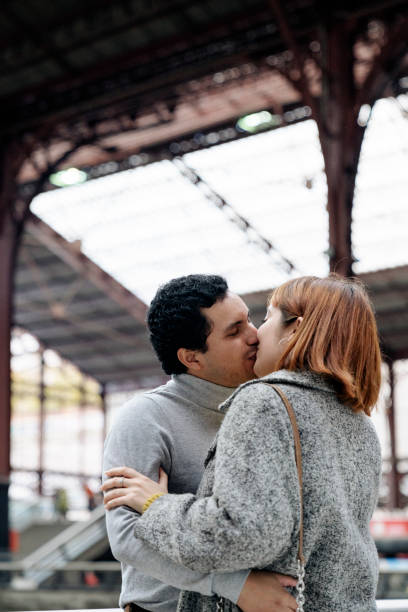 istock Couple kissing inside the train station 1194484591