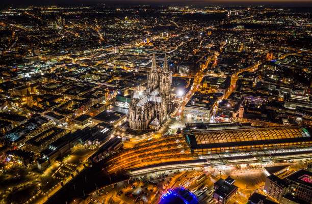Cologne Cathedral and Central Station Aerial view of Cologne Cathedral and Cologne Central Station illuminated a night. Aerial view. Germany - Europe koln germany stock pictures, royalty-free photos & images