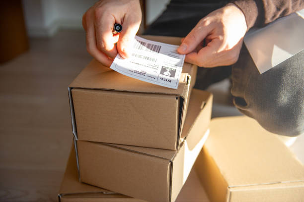 istock Delivery service, applying a shipping label 1194485281