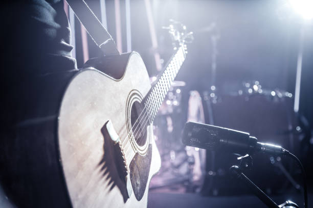 istock The Studio microphone records an acoustic guitar close-up. Beautiful blurred background of colored lanterns. 1194489064