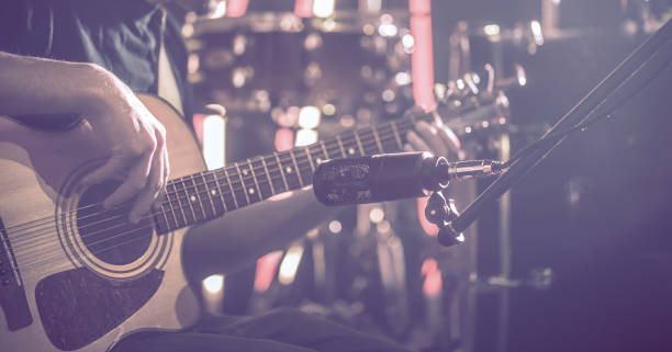 istock The Studio microphone records an acoustic guitar close-up. Beautiful blurred background of colored lanterns. 1194489068