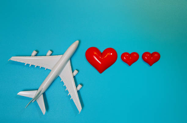 istock Miniature airplane and heart on blue background 1194491107