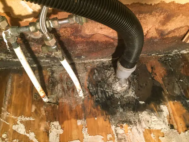 Water leak from the kitchen sink causing damage to floor an wall with mold.