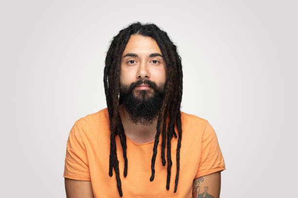 istock Young handsome bearded man hippie with dreadlocks looking at camera with blank expression 1194492417