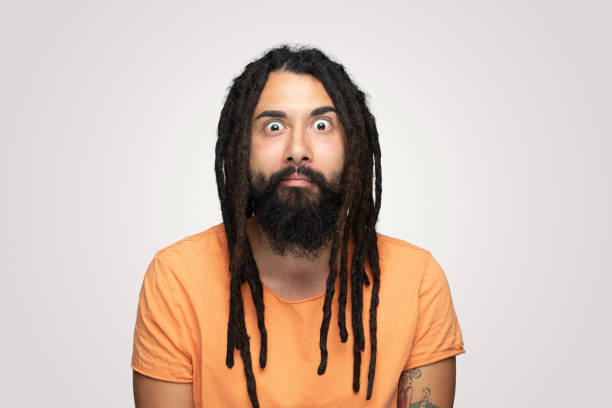 istock Young handsome bearded man hippie with dreadlocks making funny face over white background 1194492785