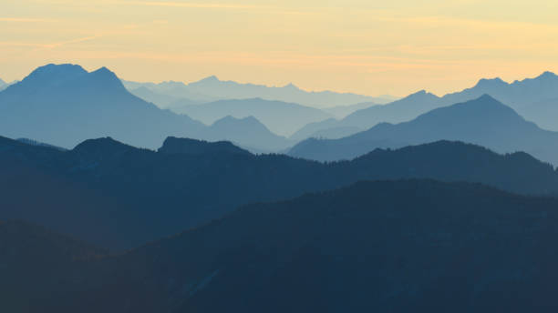 Alps mountain silhouettes and misty valleys. Misty awaking