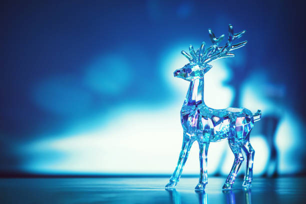 Crystal glass deer on ice with sunlight and shadows on background. Christmas decoration. Copy space.