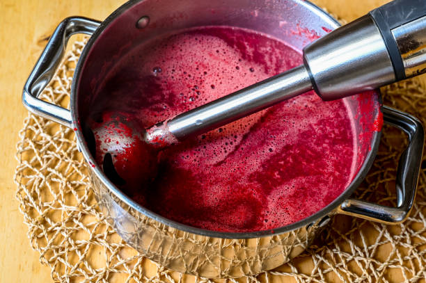 Immersion blender in pot with beetroot soup. stock photo