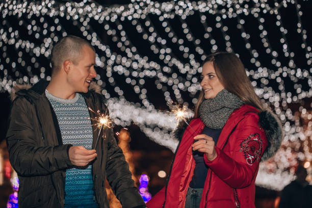 istock Young happy couple  holding hands having fun with  sparklers 1194499129