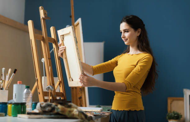 istock Woman holding a canvas and looking at it 1194499715