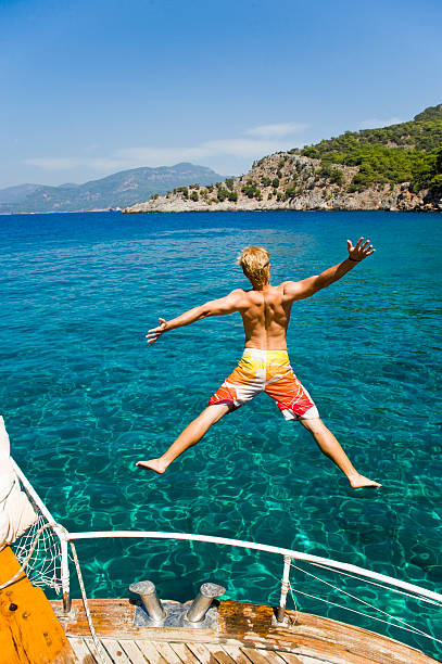 Young Man Jumping Into The Sea stock photo