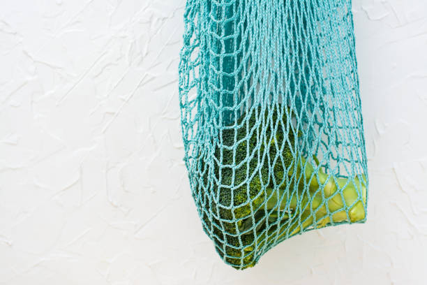 istock Fresh raw broccoli hanging in a reusable string bag on a light background. Healthy lifestyle, nutrition and zero waste concept 1194503885
