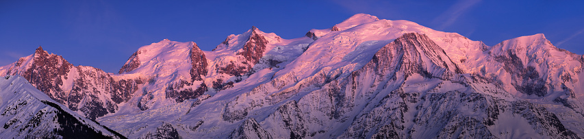 Dawn light illuminating the snow capped spire of Ama Dablam (6812m) with its dramatic rocky ridges and precipitous hanging glaciers high in the picturesque Himalaya mountain wilderness of the Everest National Park, a UNESCO World Heritage Site.