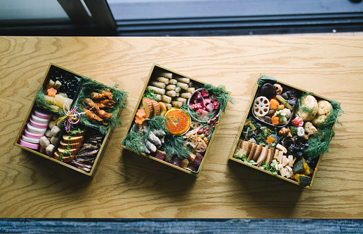 Top down shot of Osechi Ryori on a wooden table.