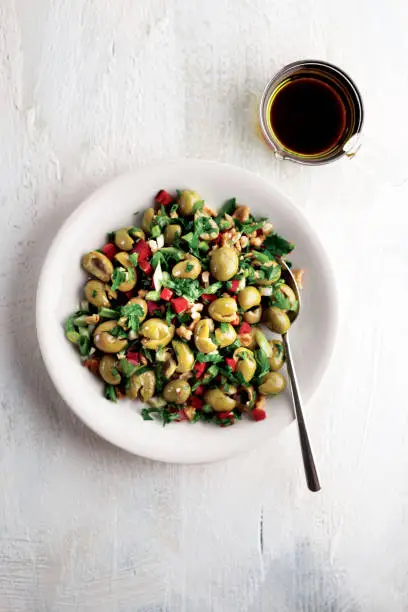 Photo of Green olives and walnuts,Olives assortment in plate with oil,Green olives,olives salad