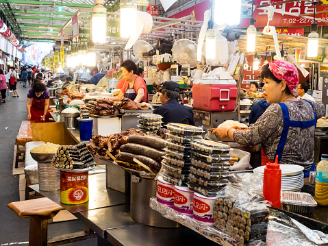 Seoul, South Korea - June 26, 2017: Sellers sitting at the counter of the Gwangjang food Market in Seoul.