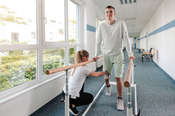 Young man in walking rehabilitation course after a sport injury Young man in walking rehabilitation course after a sport injury on his knee sports physical stock pictures, royalty-free photos & images