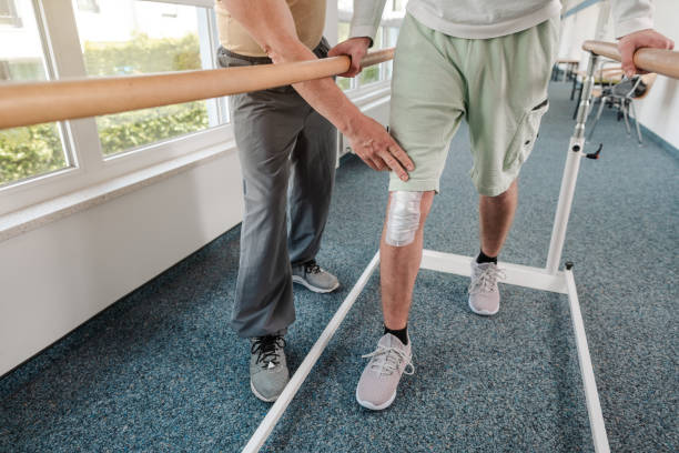 istock Young man learning to walk again in rehabilitation 1194506851