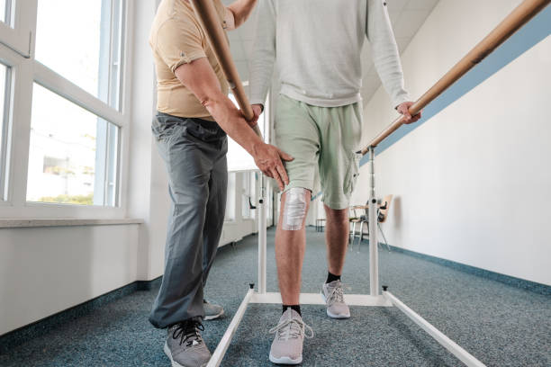 istock Young man learning to walk again in rehabilitation 1194506870