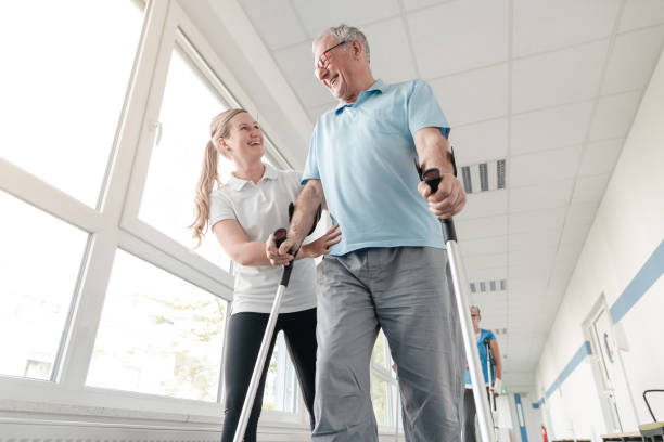 senioren in der rehabilitation lernen, wie man mit krücken geht - alternative medizin fotos stock-fotos und bilder