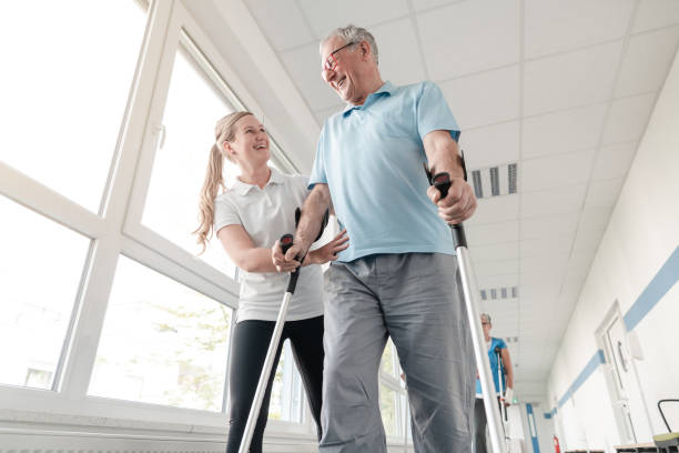 anziani in riabilitazione imparando a camminare con le stampelle - clinica di allenamento sportivo foto e immagini stock