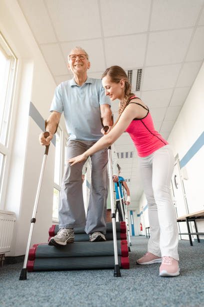 istock Seniors in rehabilitation learning how to walk with crutches 1194509020