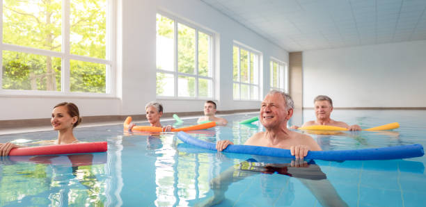 femmes et hommes dans des exercices d'eau pendant la remobilisation - hydrothérapie photos et images de collection