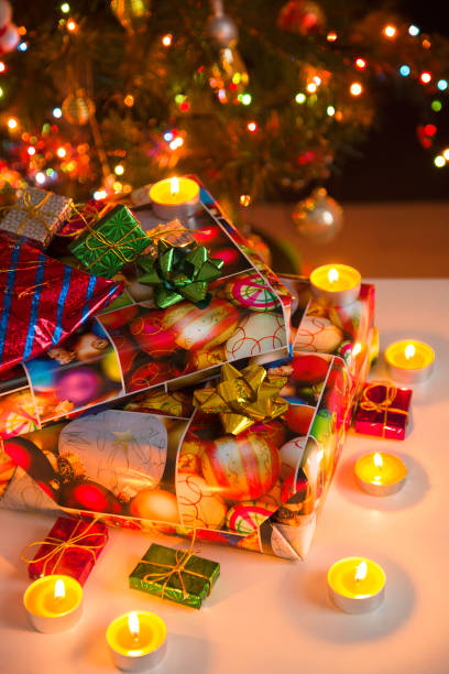 istock Gift boxes and burning candles under the Christmas tree, vertical 1194511275
