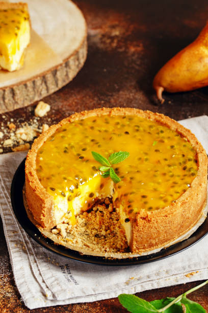 istock Cheese cake with passion fruit on a dark background. Cheese cake with passion fruit sauce on top, decorated with mint leaves. 1194511646
