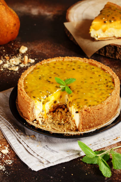 istock Cheese cake with passion fruit on a dark background. Cheese cake with passion fruit sauce on top, decorated with mint leaves. 1194511677