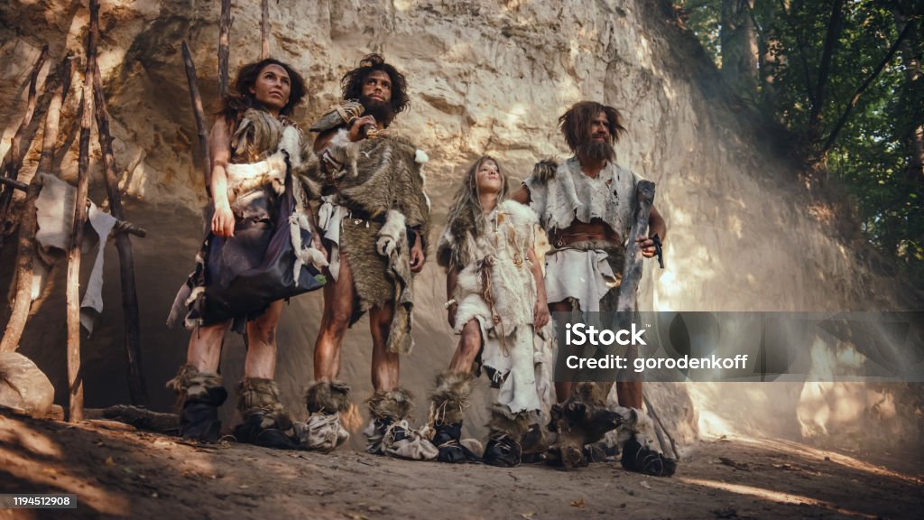 Tribe Of Four Huntergatherers Wearing Animal Skin Holding Stone Tipped Tools Pose At The Entrance Of Their Cave Portrait Of Two Grown Male And Two Female Neanderthals And Their Way Of Living Tribe Of Four Huntergatherers Wearing Animal Skin Holding Stone Tipped Tools Pose At The Entrance Of Their Cave Portrait Of Two Grown Male And Two Female Neanderthals And Their Way Of Living