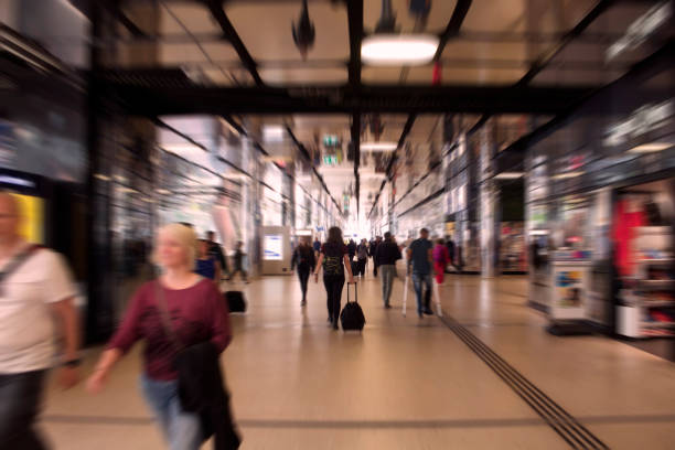 Blurry motion image of people walking at the main train station called Amsterdam Centraal. A major international railway hub, it is used by 162,000 passengers a day. Transportation concept.