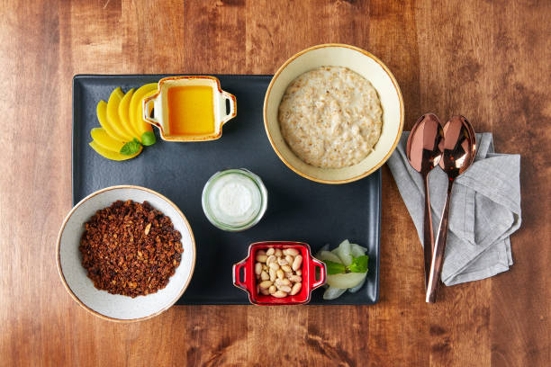 proper food tray, oatmeal and buckwheat, nuts and beans, mango and sauce, on a wooden table