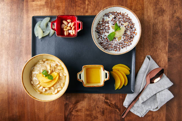 proper food tray, oatmeal and buckwheat porridge with milk, nuts and beans, mango and sauce, on a wooden table