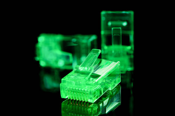 コネクタ rj-45.ネットワークおよびインターネット用のネオングリーン透明コネクタrj45。他の 2 つのコネクタ、被写界深度全体を持つ黒の背景にクローズアップ マクロ。 - cable network server network connection plug green ストックフォトと画像