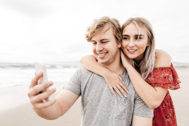 istock Couple on the beach with the camera 1194523619