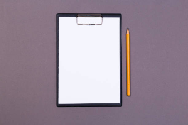 istock Clipboard with white sheet and pen on a colored background. View from above. space for text 1194526212
