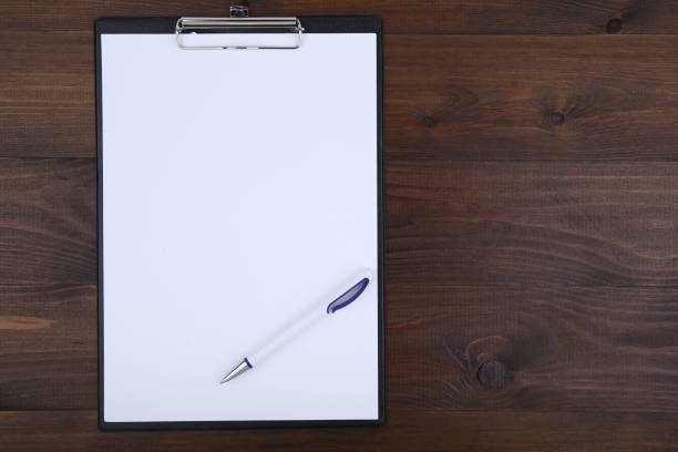 istock clipboard with empty paper and pen on wooden background 1194526806