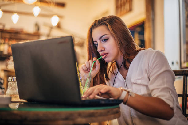 istock Young woman is using laptop and drinking soda 1194527256
