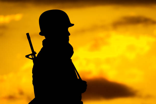 istock Soldier in silhouette looking at golden sky. 1194528531