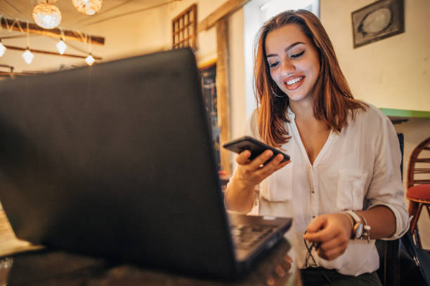 istock Pretty girl is text messaging and using laptop 1194528665