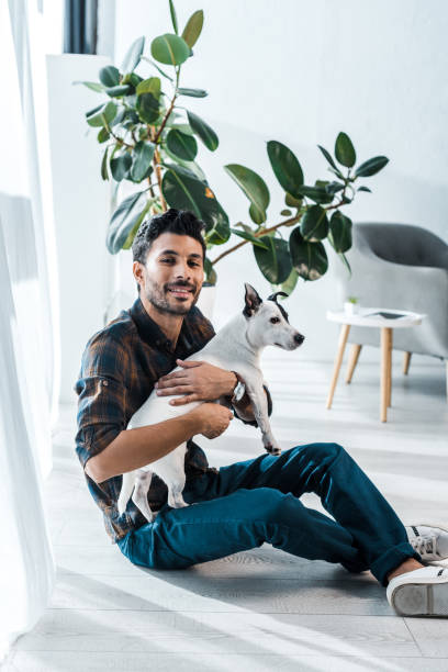 istock smiling and handsome bi-racial man holding Jack Russell Terrier 1194530791