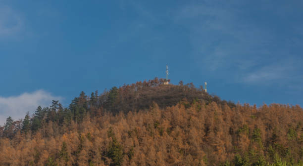 istock Hill over Perstejn village with blue sky and color forest 1194531252