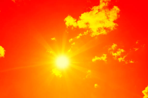 istock Bright sun with beautiful beams in the sky with clouds (toned in red) 1194532454