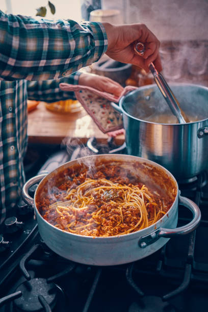 preparare spaghetti alla bolognese fatti in casa - tomato sauce domestic kitchen meat cheese foto e immagini stock