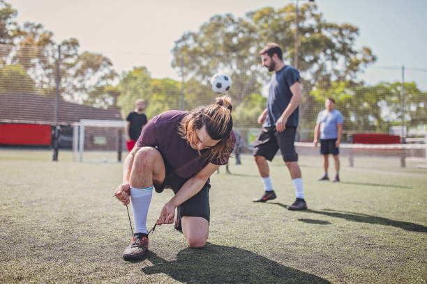 istock Male soccer player tying shoelace 1194534501