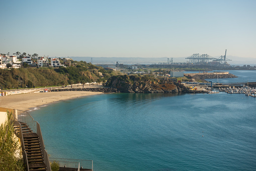 Playa de Sines al atardecer con grúas terminales de puerto de contenedores detrás, en Portugal photo