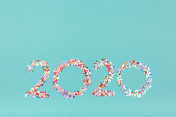istock Creative number 2020 written in multicolored glitter on a mint color background. 1194538213