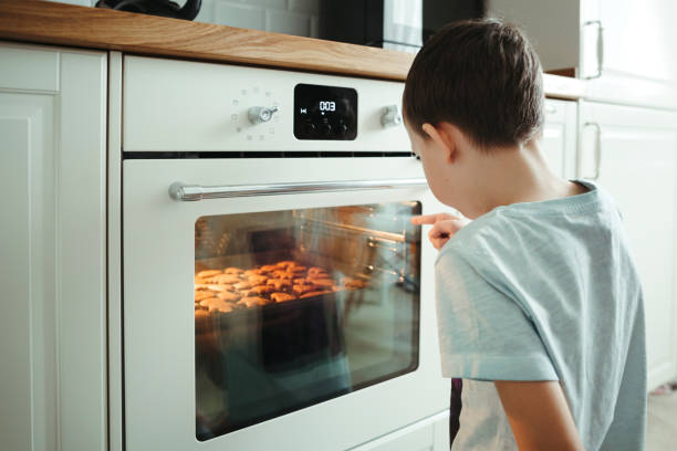 Young boy cooking chocolate chip cookies. stock photo