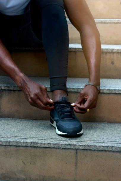 istock Athlete during running tying shoelaces on sneakers on stairway, jogger training and doing workout in downtown city. 1194539608